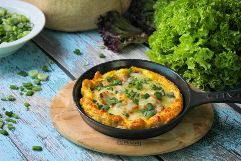 fritada feita com ovos, tomate, abobrinha e óleo essencial de tomilho com tomilho por cima